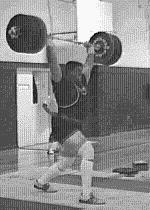 5. Once standing, the lifter begins the jerk element of the clean and jerk by dipping down slowly, keeping the torso vertical. 6.