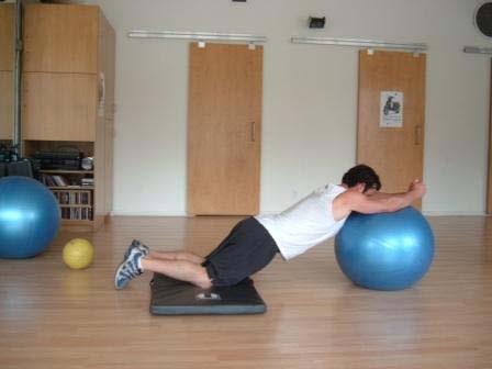 Brace your abs and slowly lean forward and roll your hands over the ball while the ball moves away