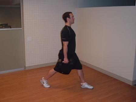 Workout A " DB Split Squat Stand with your feet shoulder-width apart and hold a light dumbbell in each hand.
