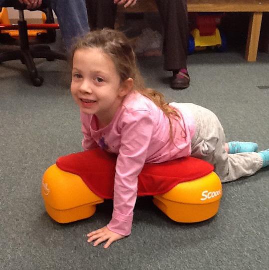 Ella worked hard on transitioning from a seated position into prone on the Scooot and back to a seated position.