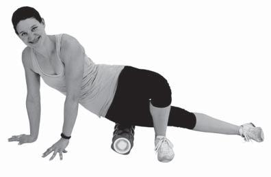 Leaning back, place your hands on the floor behind the roller and start to move your knees and hips to one side.