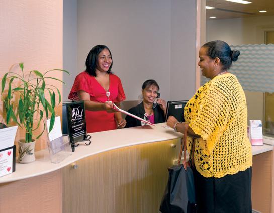 Betty Torres and Deoranee Budhram, admitting registrars at the Carol H. Taylor Breast Health Center, check in a patient.