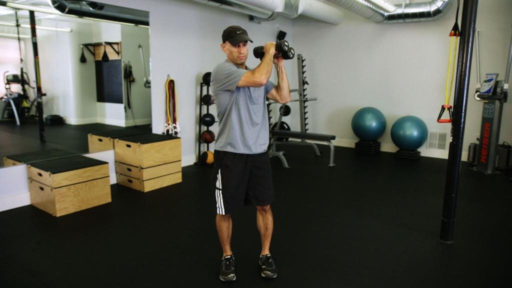 Engage that glute to stand, lifting the weights to the opposite shoulder. Keep knees tracking over toes.