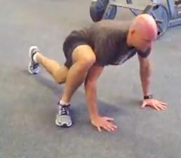 Keep your abs braced, pick one foot up off the floor, and slowly bring your knee up outside of your