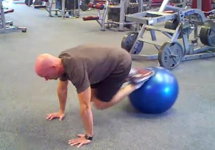 Keeping your back straight (don't round it), roll the ball as close to your chest as possible by contracting your abs and pulling it forward.