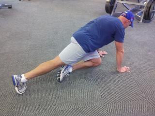 Keep your abs braced, pick one foot up off the floor, and slowly bring your knee