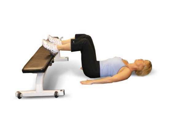 A2 Bench Bridges - Lie with your back flat on the floor and your knees bent, feet resting on a bench.