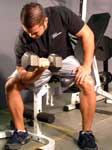 Rest your elbow on the inside of your thigh and let the dumbbell hang. Rest your other hand on the top of your other thigh for support.