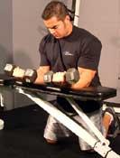 the bench. Hold dumbbells with your palms up. Place forearms flat on the bench with the back of your wrists on the edge of the bench.