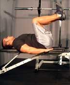 Lie on a flat bench with your legs off the end. Place your hands under your butt with your palms down.