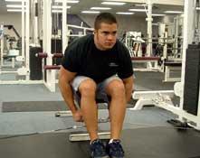 Tips: Sit at edge of bench with feet placed beyond knees. Rest torso on thighs.