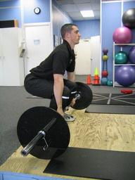 Deadlift How To: Bar should be on the floor (a dead stop hence the name). Grasp the bar with an overhand grip, and place your shins against the bar touching it.