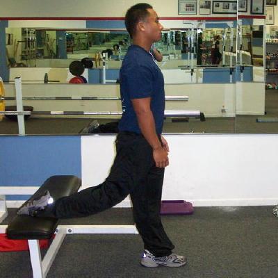 Facing away from the bench place one foot on the bench and one foot out about two to three feet in front of the bench. You will now be in a modified lunge position.