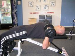 Dumbbell Press How To: Lie on your back on a bench, with a DB in