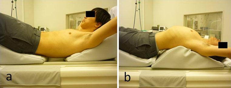 Fig. 1 Body posture during flexion (a) and extension (b) on computed tomography.