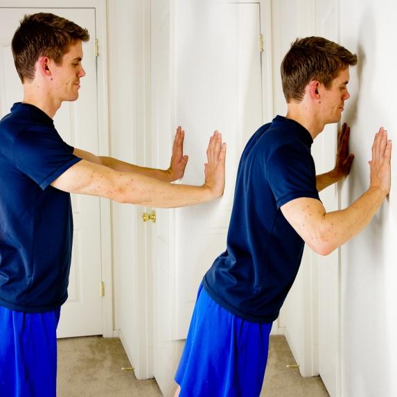 WALL PUSH UPS Standing at a wall; place your arms out in front of you with your