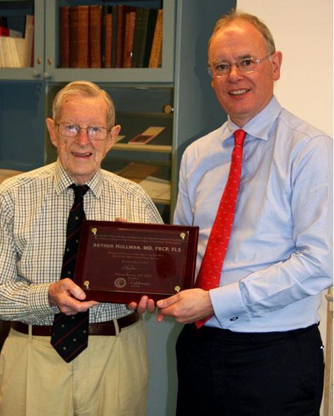 Dr. Arthur Hollman receiving CAACC commemorative plaque from Dr.