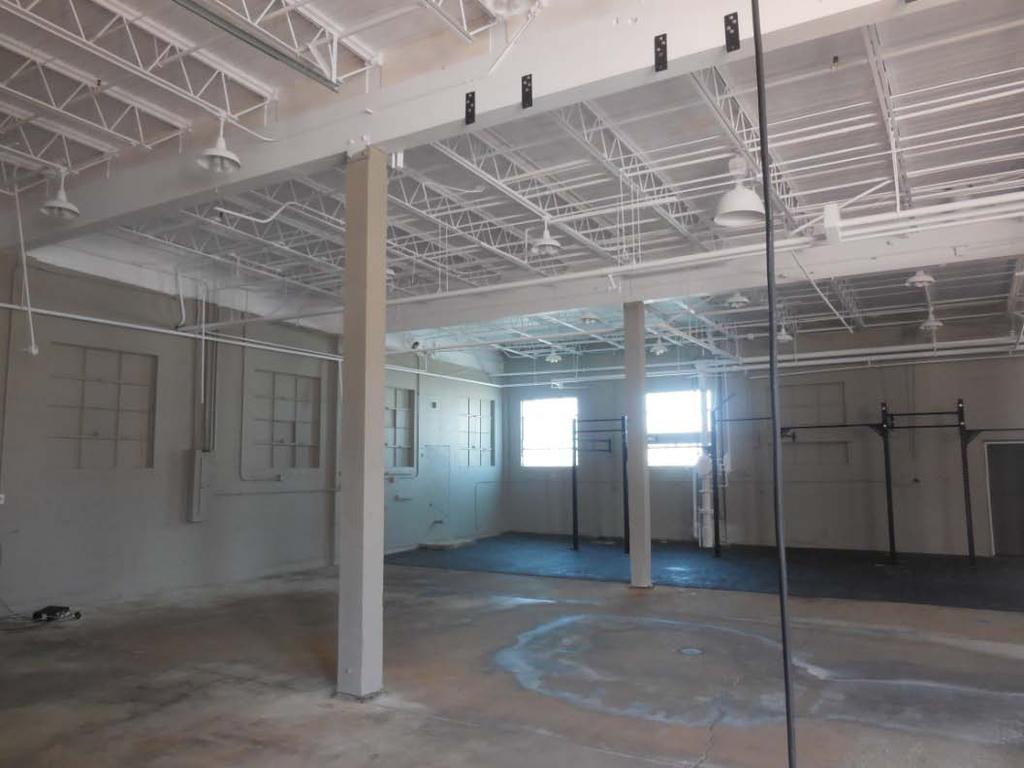 Crossfit, Suite 180. White LBC encapsulated ceiling, trusses, beams, plumbing, and electrical.