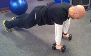 Lower one dumbbell to chest level while keeping the other dumbbell