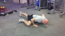 As you lower yourself, slowly bring your right knee up to your right elbow. Keep your foot off the ground as you do so.