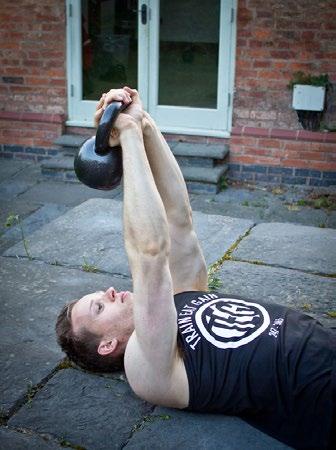 Hold a kettle bell directly above your shoulders, with both hands.