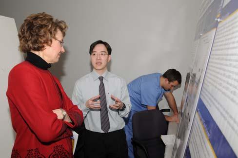 Senior dental student Mark Sorensen (right) discusses his poster with Jeremy Goodson (D3). (left to right): Dr.