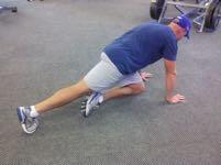 Keep your abs braced, pick one foot up off the floor, and slowly bring your knee up to your opposite