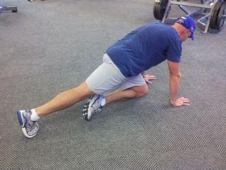 Keep your abs braced, pick one foot up off the floor, and slowly bring your knee up