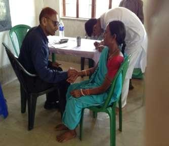 Dr Suman Dube writing prescription for a patient at the medical camp at