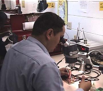 staff with the Navy Ergonomics Program observed technicians in the 2M Microelectronics Shop (69 B) continually working in awkward postures and performing tasks that necessitated repetitive motions.