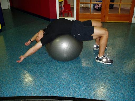 Rectus Abdominis Sit on a Swiss Ball, then walk your legs out and roll backwards until you are lying over the ball, with your arms extended over your head.