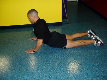 Inhale deeply and begin pressing your body upward as though doing a push up, but leave your pelvis on the ground.