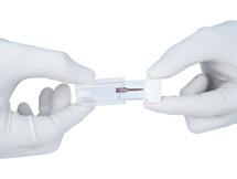 The sterile blister pack must not be opened prior to use. Open the vial by gripping the white stopper with one hand while holding the transparent part in the other.