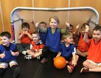 A parent attends the class working together with their child to help with fun activity songs and ball skills.