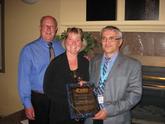 Dennis Domenichini, (r) Chair of the Canadian Institute for NDE receives his Fellowship award from Barry DeLong (l) and Cindy Finley (center).