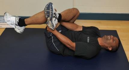 BUTTOCKS AND HIP STRETCH 1. Lie flat on your back with one leg crossed over the knee of the straight leg. 2.
