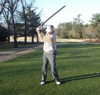 Perform a normal swing taking the bar back to the top of your backswing (see photo A).