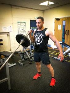 Set up a barbell in a landmine unit. Hold the end of the bar in one hand and rest it on your upper chest.