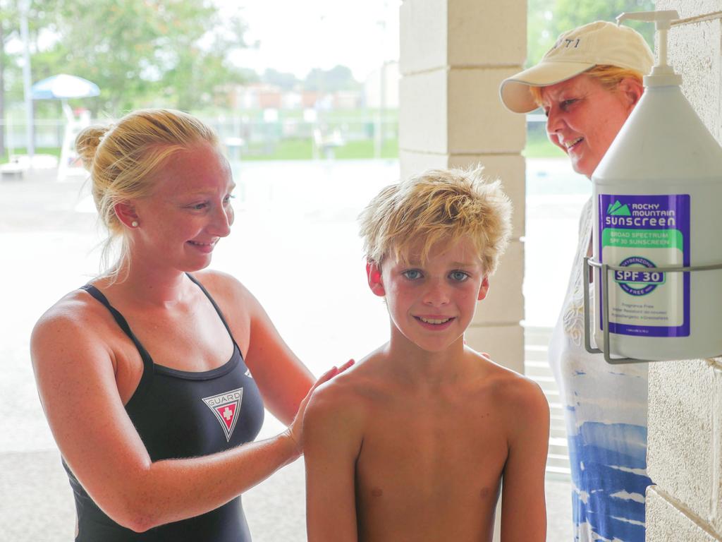 SPF sunscreen dispenser at local community pool being utilized by a lifeguard and swimmer. Photo Credit: Nick Matheson.