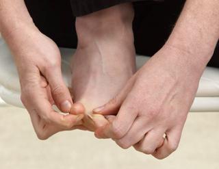 Place the 2 nd and 3 rd fingers of your R hand on the 4 th toe of your R foot to hold it in place.