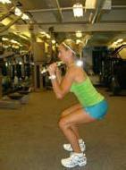 Lower into your squat position, keeping the dumbbells near your shoulders.