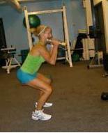 Landing back down in a full squat position, finish the dumbbell curl by