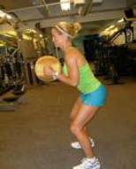 Begin to straighten your arms while in the squatting position, reaching the ball out in