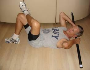 Oblique Crunch with Neck and Head Supported Lie on the back with right leg bent and foot flat on the floor with ankle of left foot on upper thigh of right leg.