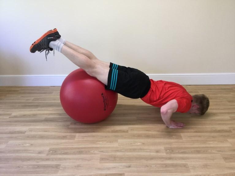Roll Out Level 1: As shown so that the ball is beneath the pelvis/upper thighs. Liken your spine to a spear, with the back of the head higher than the spine whilst looking down at the floor.