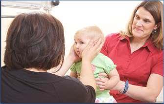 PICTURE 3: The dolls head reflex technique is being done by having the infant fixate on the examiner s face and rotating the infant s head side to side to check the integrity of her extraocular