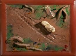 board with clay in his bare feet to make a foot print.