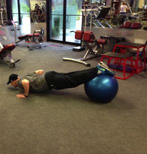 Tuck your knees to your chest by rolling the ball to your chest by contracting your abs and pulling it forward.