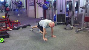 Perform an X-Body Mountain Climber by bringing one knee towards the opposite elbow, keeping