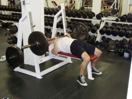 Keeping your elbows close to your sides, lower the bar straight down to the bottom of your chest.